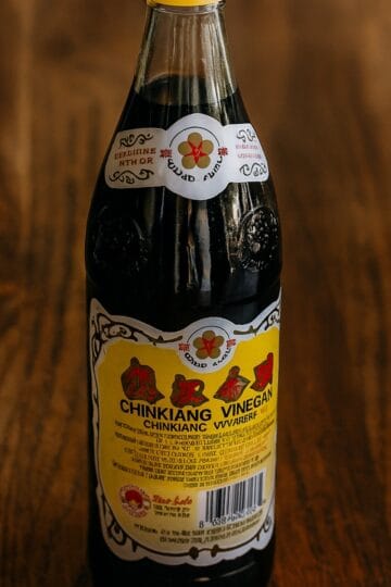 Bottle of Chinkiang black vinegar on rustic kitchen counter