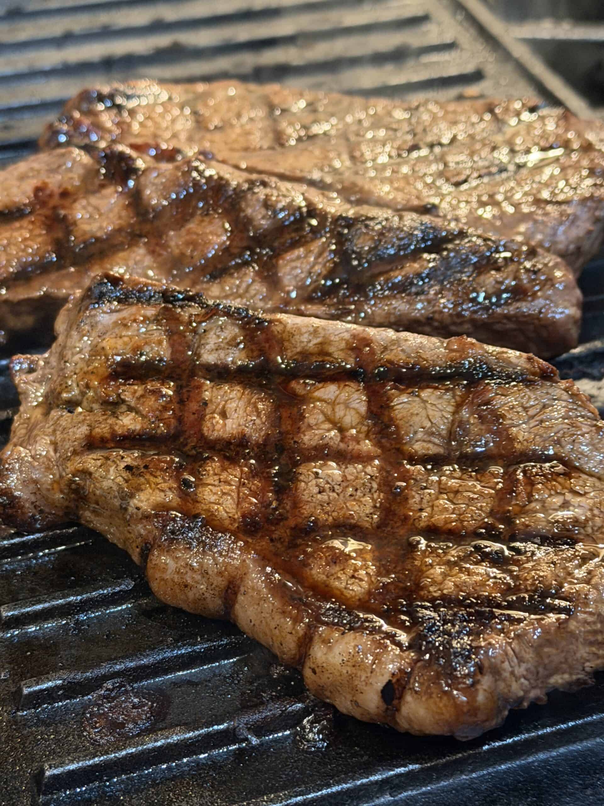 indoor grilled steak on a grill pan, showing cross marks, juicy texture