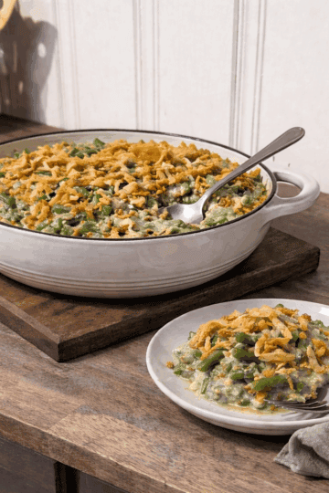 Green bean casserole with creamy mushroom sauce baked in a casserole dish, served on a small plate