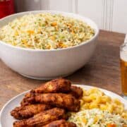 Large bowl of American vinegar coleslaw made with shredded cabbage and carrots, styled on a wooden kitchen counter.
